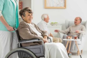 Family members compare assisted living notes on a laptop beside care questions and facility documents.